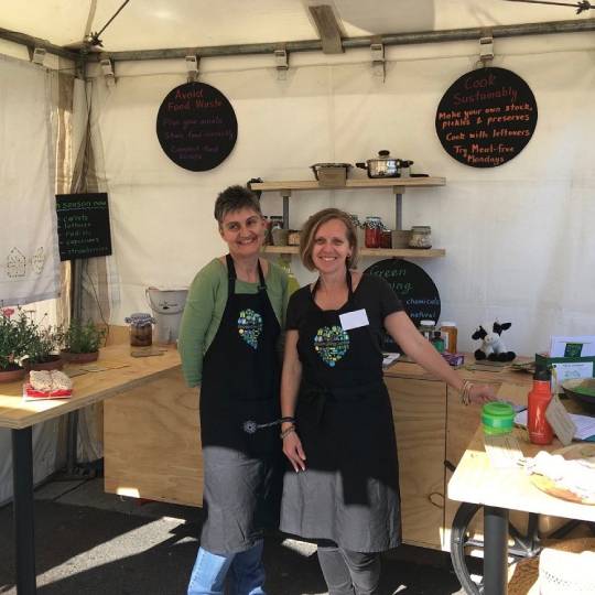 Two women standing in an outdoor kitchen